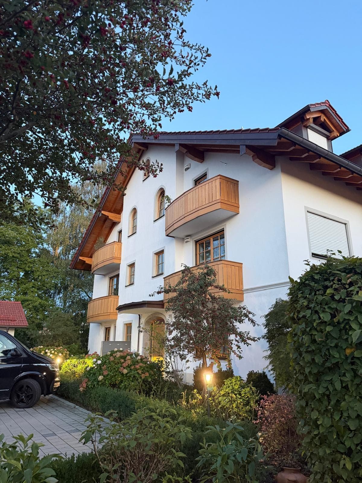 Mehrfamilienhaus mit Holzbalkonen und verputzter Fassade