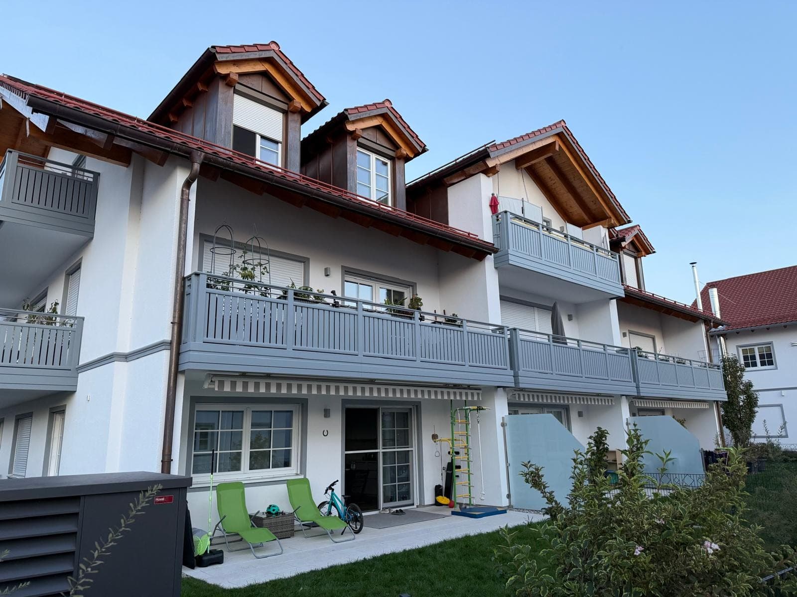 Wohnanlage mit weiß verputzter Fassade und grauen Balkongeländern